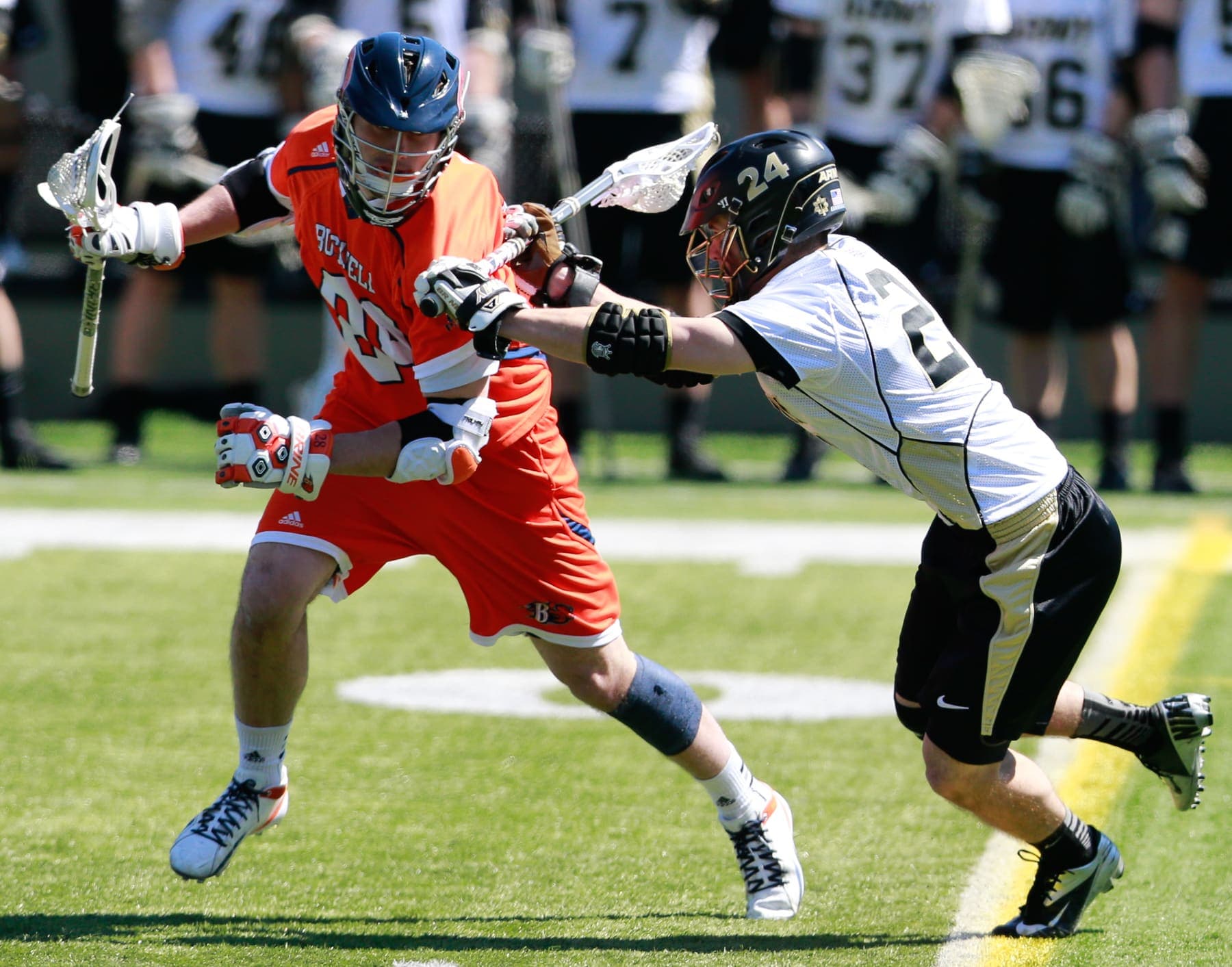 An Army defenseman pressuring a Bucknell ball carrier in a Division I lacrosse game